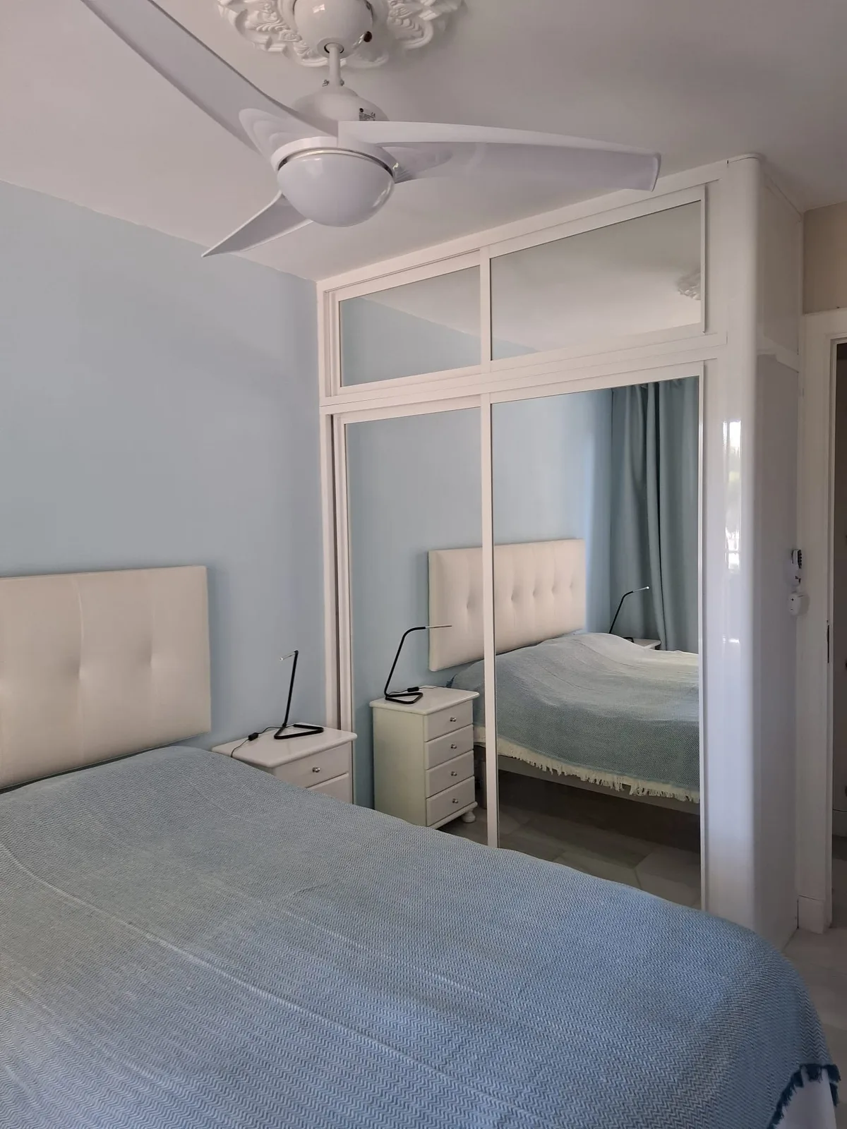 Tweede slaapkamer met twee eenpersoonsbedden en plafondventilator